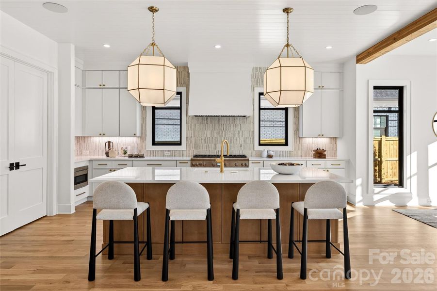 Looking toward the Kitchen from the Living Room. Beautiful backsplash. Doors on left lead to walk-in wet bar and walk-in pantry. Microwave is in left corner of the photo.