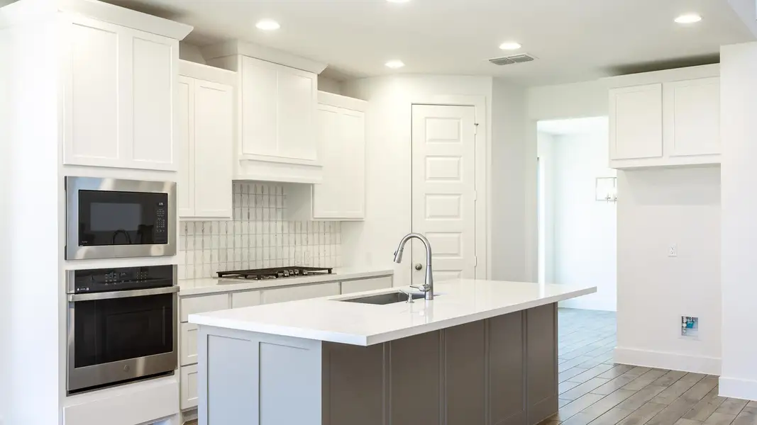 Kitchen with stainless steel appliances, tasteful backsplash, light countertops, recessed lighting, and white cabinets Kitchen with stainless steel appliances, tasteful backsplash, light countertops, recessed lighting, and white cabinets