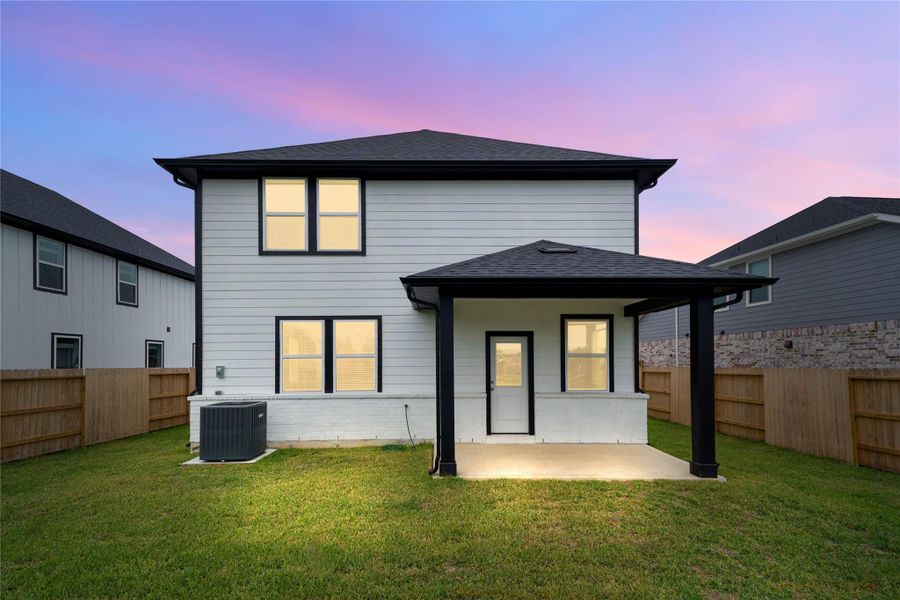 Enjoy the fresh air in this spacious backyard, offering a crisp, clean aesthetic with white siding, black accents, and a covered patio space to enjoy outdoor living! Enjoy the fresh air in this spacious backyard, offering a crisp, clean aesthetic with white siding, black accents, and a covered patio space to enjoy outdoor living!