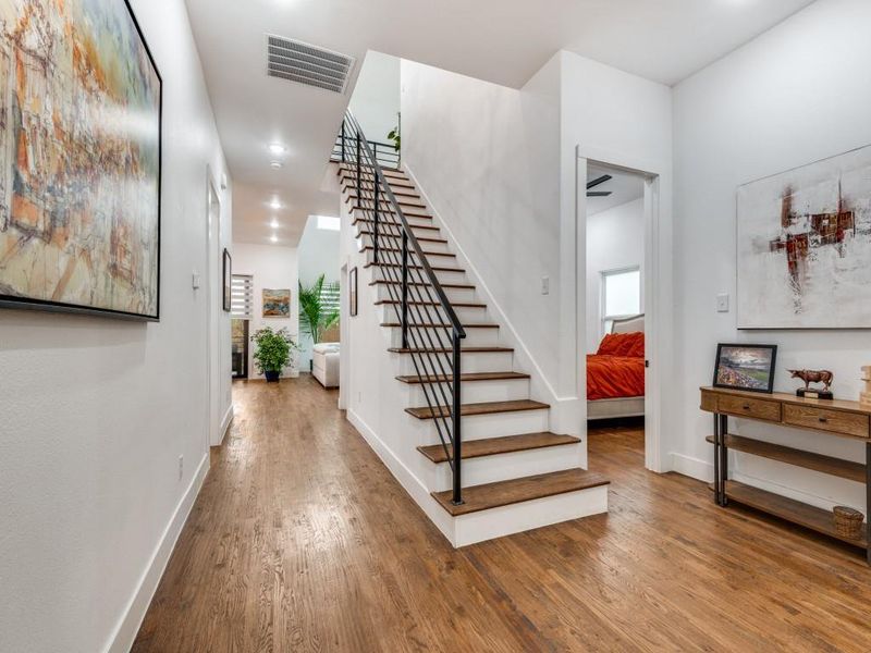 Staircase with wood finished floors and recessed lighting