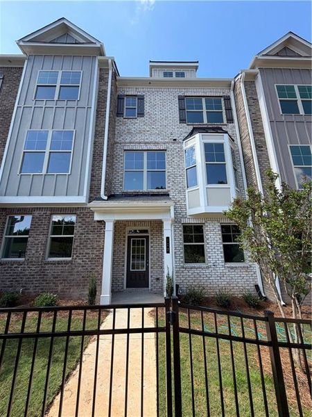 Front exterior of a new home in Towns at Enclave, Lawrenceville, GA, highlighting curb appeal (Image 1). Front exterior of a new home in Towns at Enclave, Lawrenceville, GA, highlighting curb appeal (Image 1).