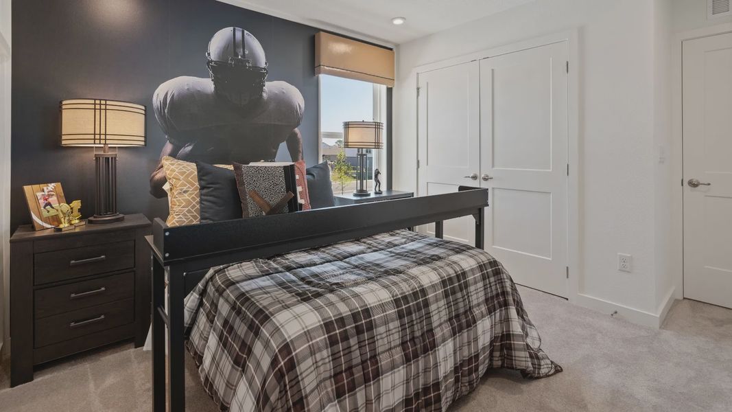 Secondary bedroom with large window and double door closet in a DRB Home Clementine model at the Trinity Place community.