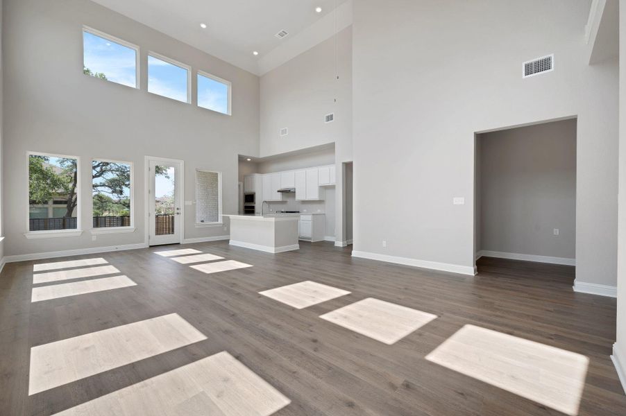 Unfurnished living room featuring dark wood-style flooring and baseboards
