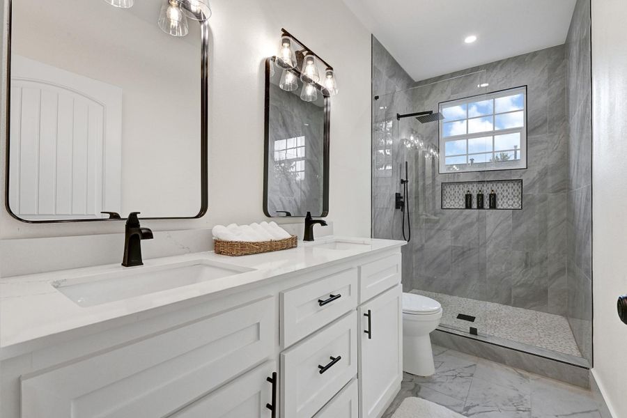 Spacious second bathroom with dual-sink vanity and elegant finishes. Spacious second bathroom with dual-sink vanity and elegant finishes.