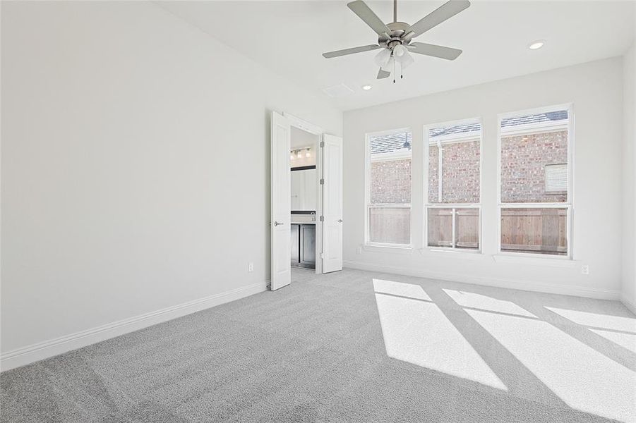 Carpeted spare room with ceiling fan