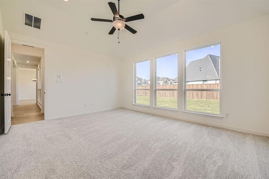 Spare room featuring light colored carpet and ceiling fan