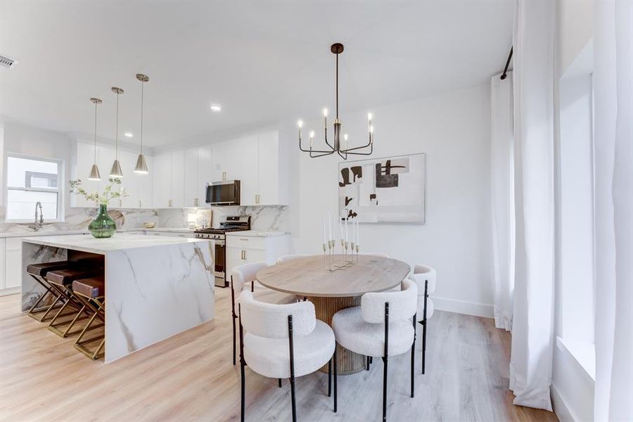 The dining area is open to the kitchen, living room, and second floor balcony.