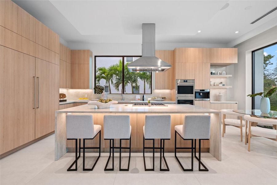 Modern chef’s kitchen with a waterfall island, premium appliances, custom cabinetry, and seating for four with garden views. Modern chef’s kitchen with a waterfall island, premium appliances, custom cabinetry, and seating for four with garden views.