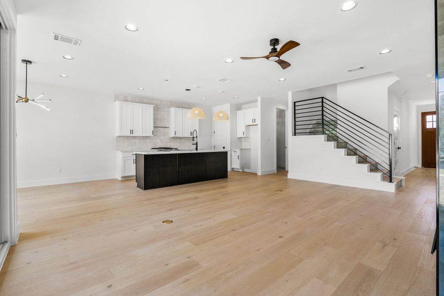 Kitchen with light wood-style flooring, visible vents, open floor plan, and ceiling fan