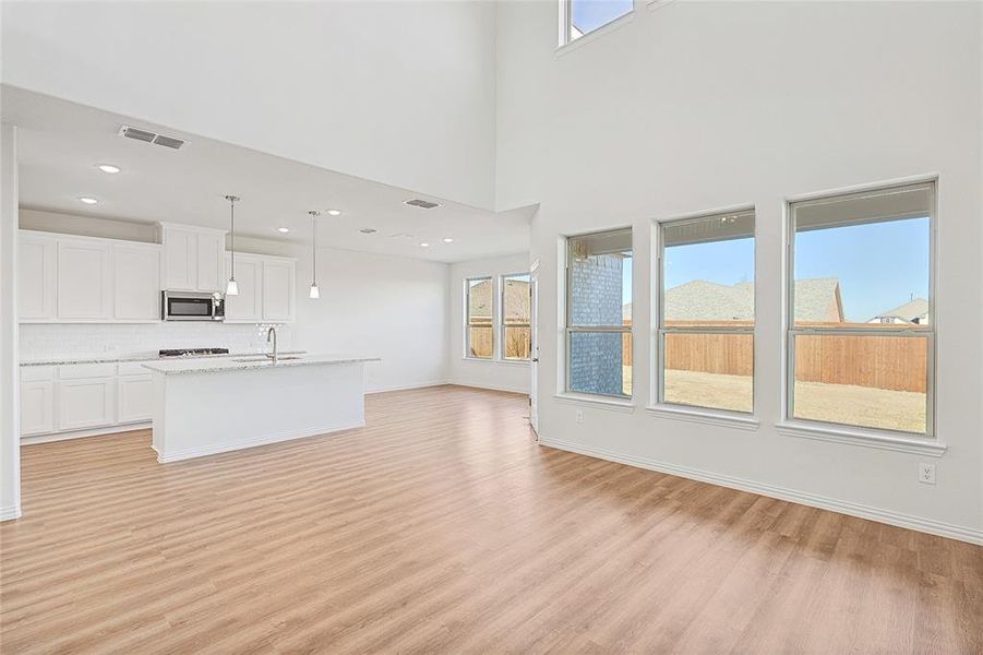 Unfurnished living room featuring light wood-style flooring and baseboards