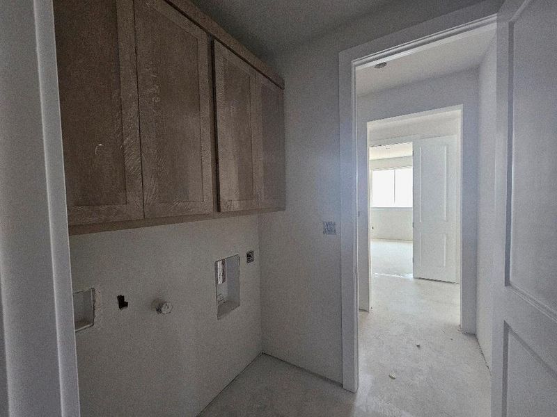Washroom featuring cabinet space and hookup for an electric dryer Washroom featuring cabinet space and hookup for an electric dryer