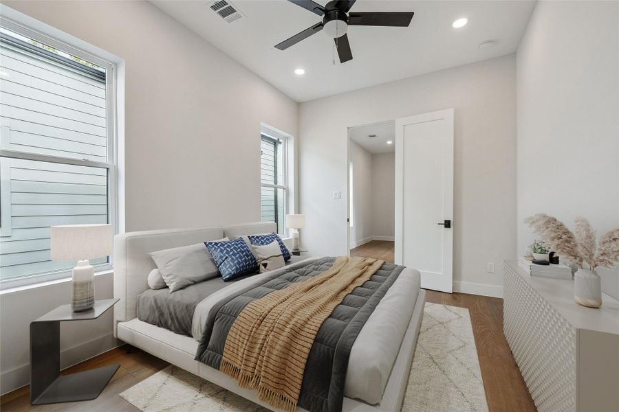 Another view of this secondary bedroom shows the light moving through the room from multiple angles, helping the space feel open without feeling oversized. Wide-plank flooring continue throughout the secondary bedroom. (digitally staged) Another view of this secondary bedroom shows the light moving through the room from multiple angles, helping the space feel open without feeling oversized. Wide-plank flooring continue throughout the secondary bedroom. (digitally staged)