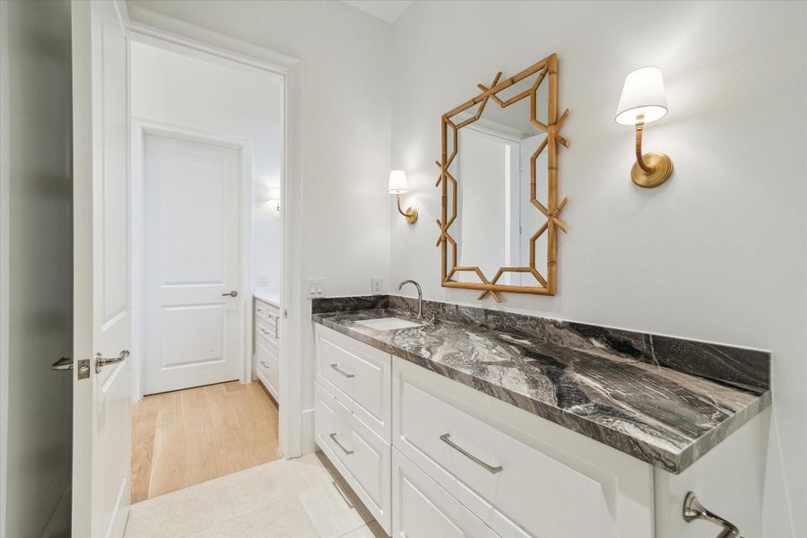 [Guest Powder Room/ Future Pool Half Bath]This marble-clad half bath adjoins the butler's pantry and has an exterior door.