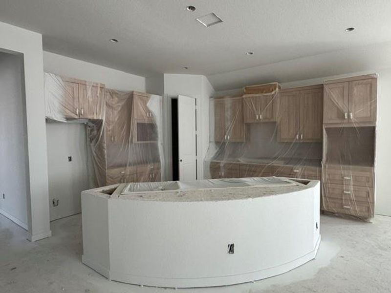 An unfinished kitchen presents a blank canvas for customization, with cabinetry wrapped and ready for final touches. An unfinished kitchen presents a blank canvas for customization, with cabinetry wrapped and ready for final touches.