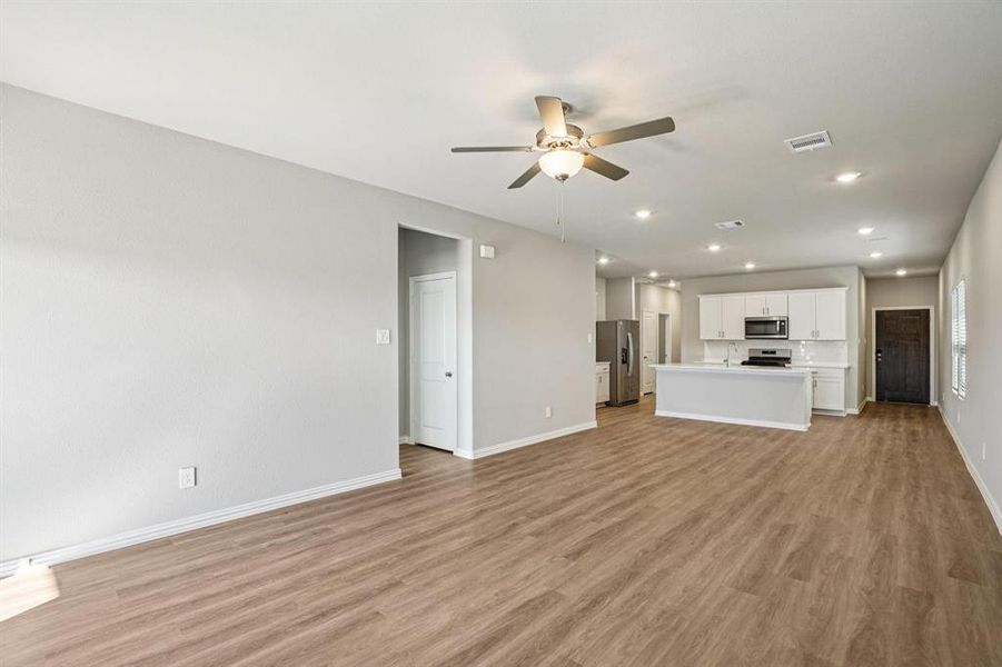 Unfurnished living room with ceiling fan, recessed lighting, and light wood finished floors