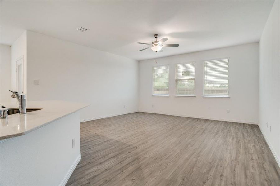 Unfurnished living room featuring light wood-style flooring and a ceiling fan