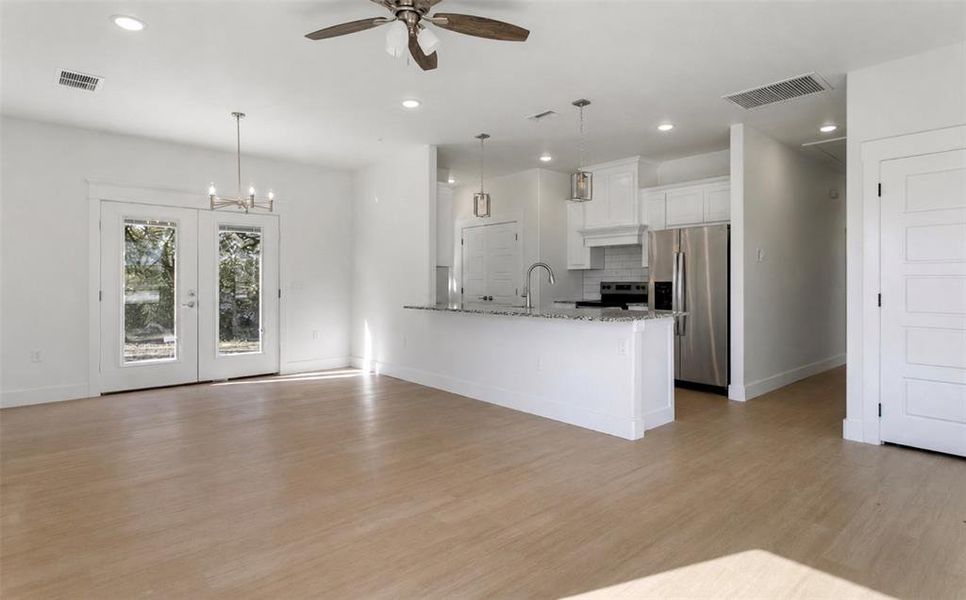 Open-concept living space featuring wood-finish flooring, recessed lighting, and a ceiling fan Open-concept living space featuring wood-finish flooring, recessed lighting, and a ceiling fan