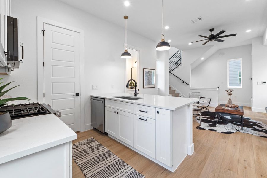 Gleaming stone countertops and warm wood floors define this open concept interior layout.