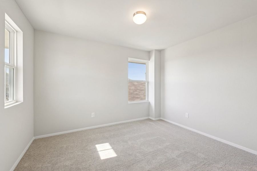Image of a bedroom with grey walls, tan carpeting and a window