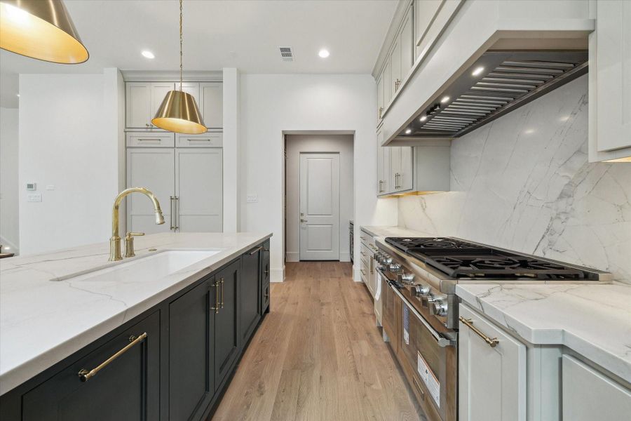 The kitchen showcases a premium Thermador appliance package, which includes a 48” Pro Harmony gas range, a 24” built-in MicroDrawer microwave, a 24” custom panel dishwasher, a 30” custom panel fresh food refrigerator, and 30” freezer columns.
