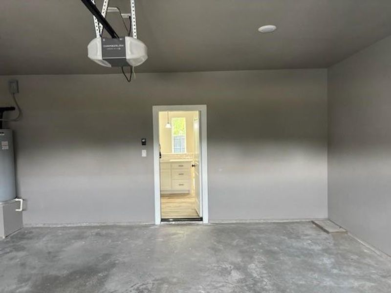Garage featuring water heater and a garage door opener Garage featuring water heater and a garage door opener