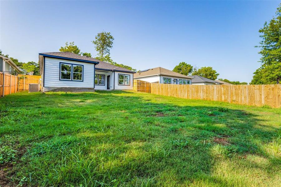 Back of house featuring a lawn and central air condition unit