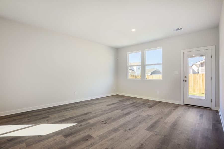 A room with a wood floor and windows.
