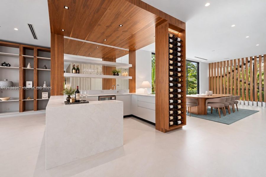 Custom bar area featuring stone-finish counters, built-in floor-to-ceiling wood wine storage, wood-paneled ceiling accent, recessed lighting, and integrated shelving