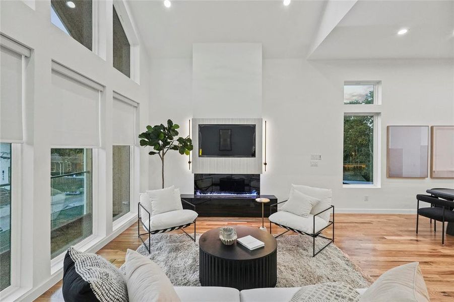 Living room with light wood-type flooring and a high ceiling