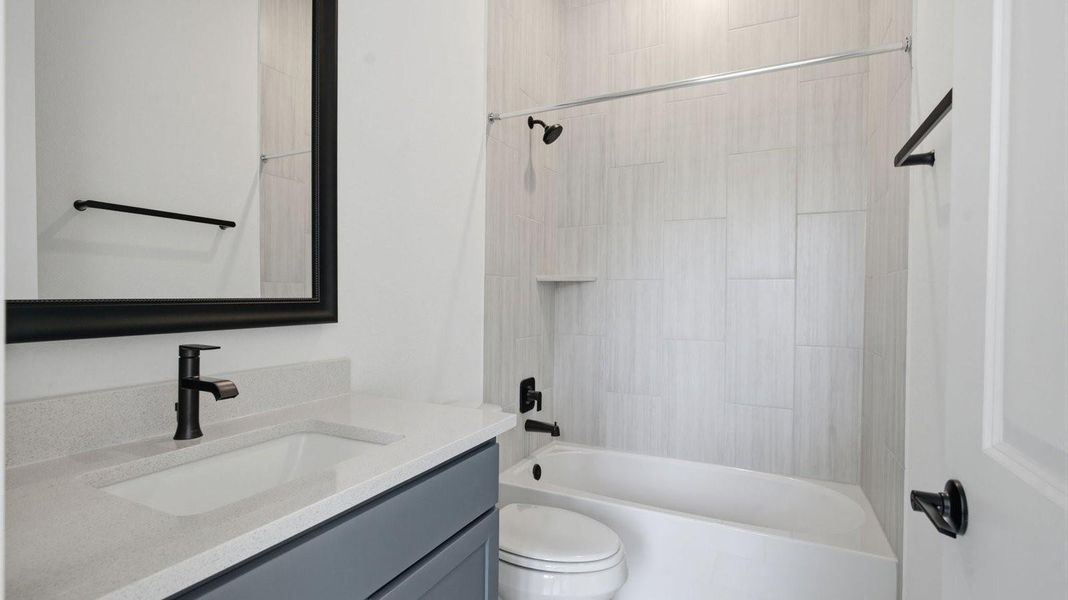 A secondary bathroom with a standing tub, one sink vanity, and a window for natural lighting