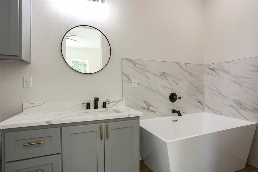 Bathroom featuring vanity and a washtub