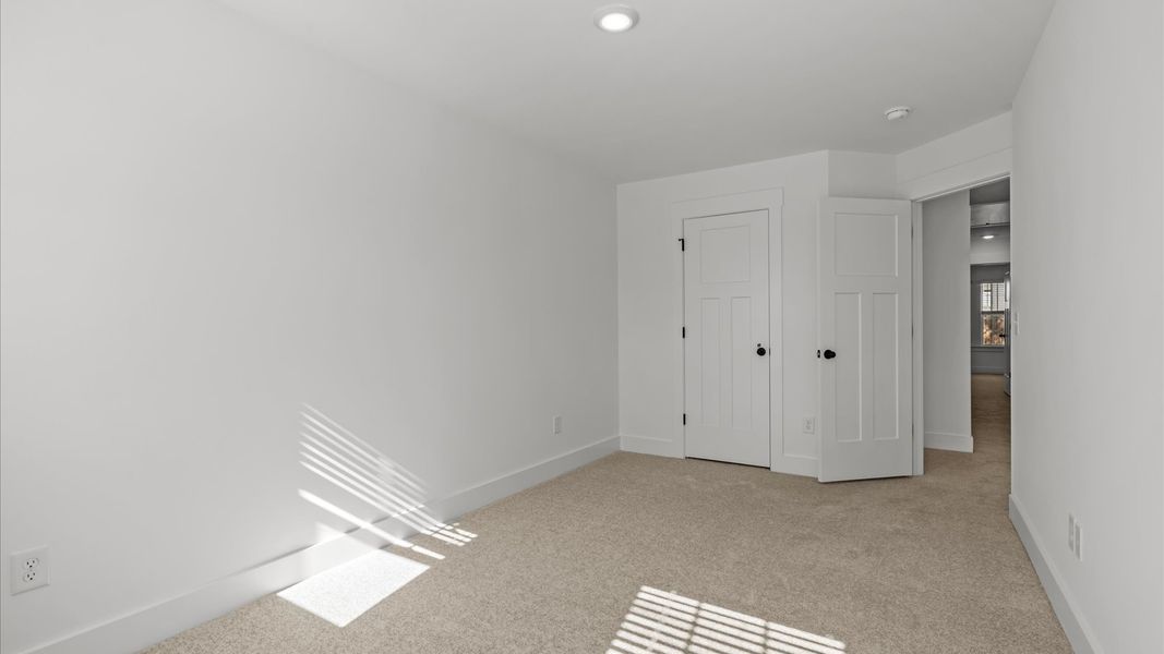 Notable secondary bedroom offering cozy carpeted flooring and a stylish walk-in closet