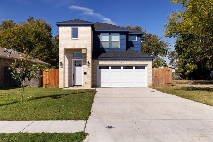 View of front of house featuring a front yard and a garage