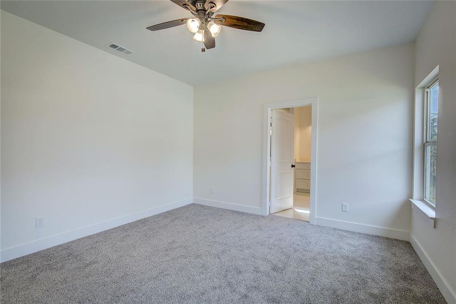 Unfurnished room with light colored carpet and a ceiling fan Unfurnished room with light colored carpet and a ceiling fan