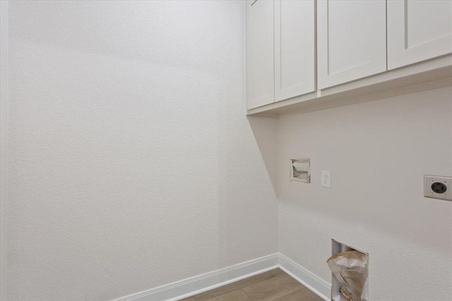 Laundry area with cabinet space, hookup for an electric dryer, washer hookup, and light tile patterned floors Laundry area with cabinet space, hookup for an electric dryer, washer hookup, and light tile patterned floors