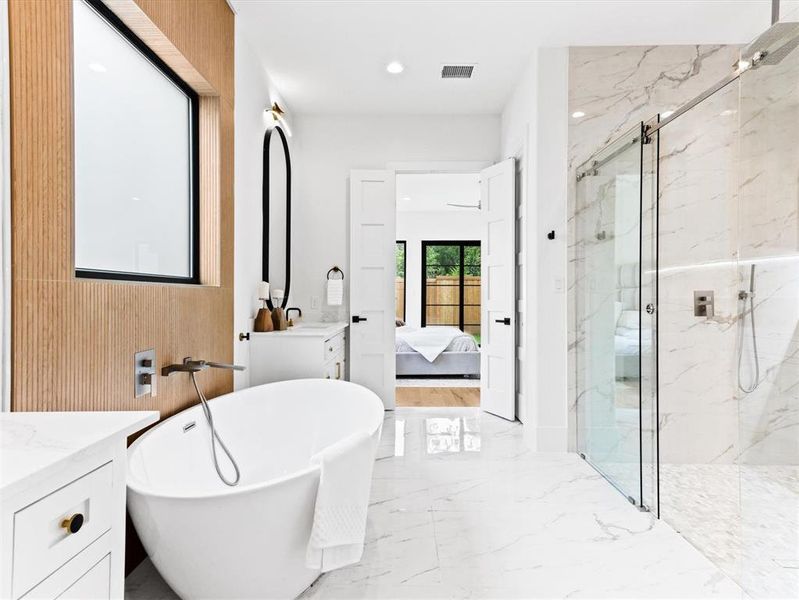 Bathroom with tile flooring, shower with separate bathtub, and vanity