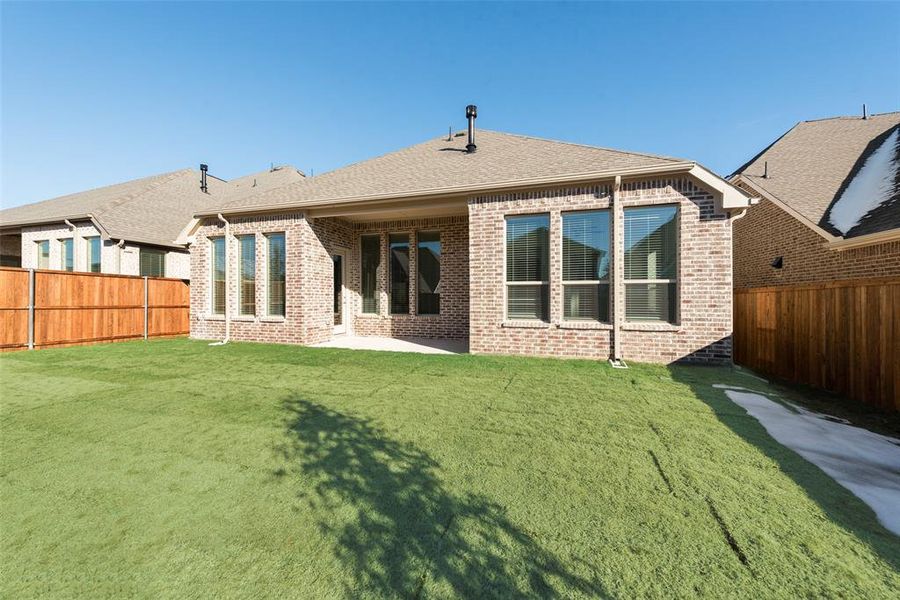 Rear view of property with a yard and a patio