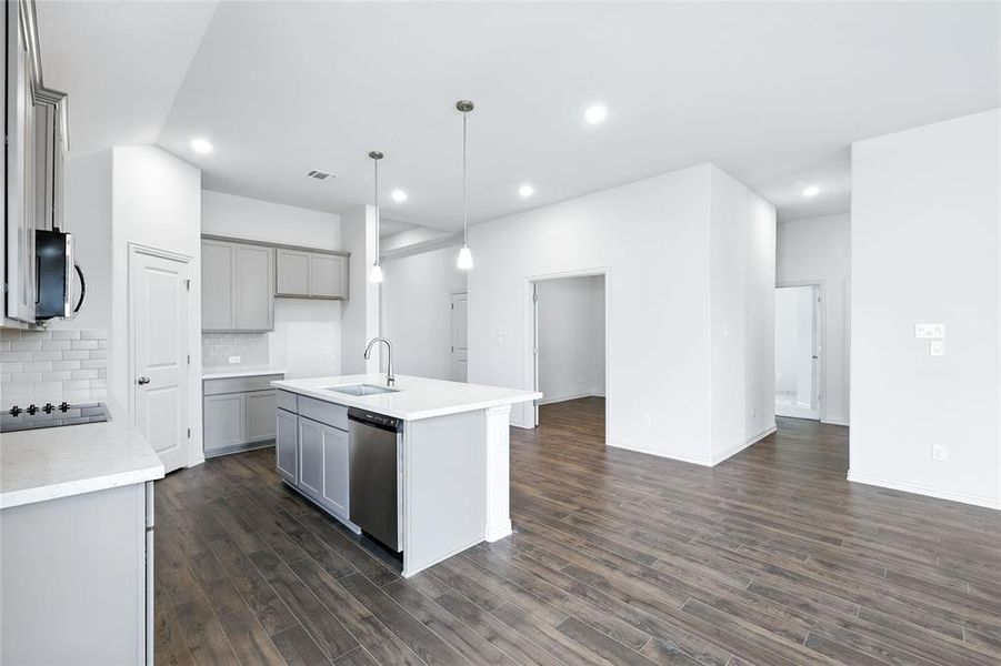 Kitchen with decorative backsplash, gray cabinetry, a kitchen island with sink, decorative light fixtures, and recessed lighting Kitchen with decorative backsplash, gray cabinetry, a kitchen island with sink, decorative light fixtures, and recessed lighting