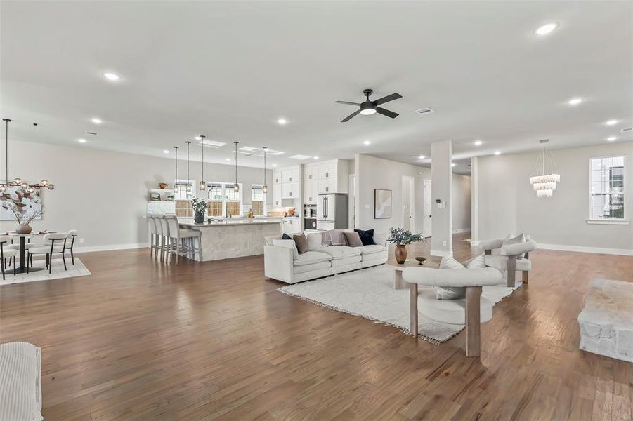 Living room with dark wood-type flooring, a chandelier, recessed lighting, and ceiling fan Living room with dark wood-type flooring, a chandelier, recessed lighting, and ceiling fan