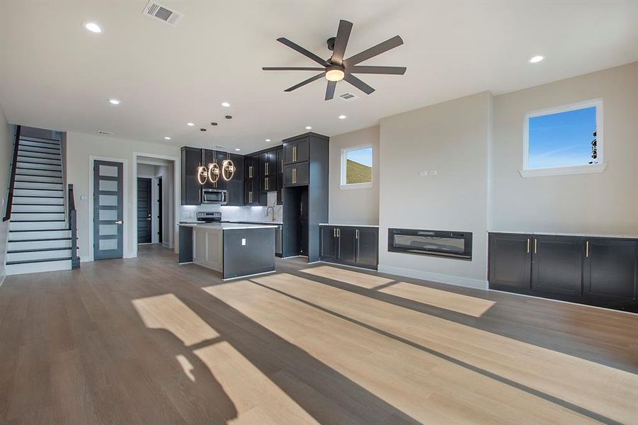 Unfurnished living room featuring ceiling fan and wood-type flooring