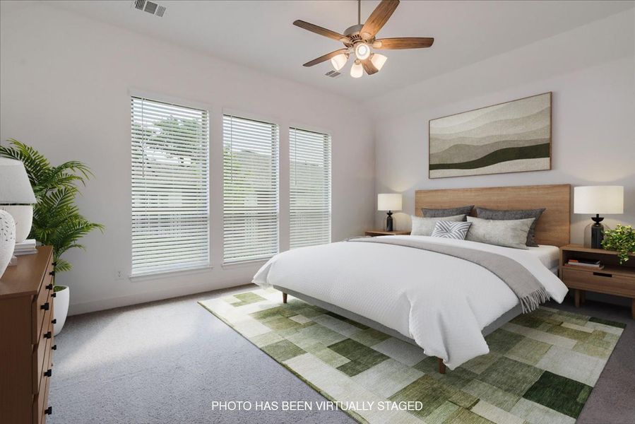 This room features a ceiling fan, three windows with blinds, and carpeted flooring