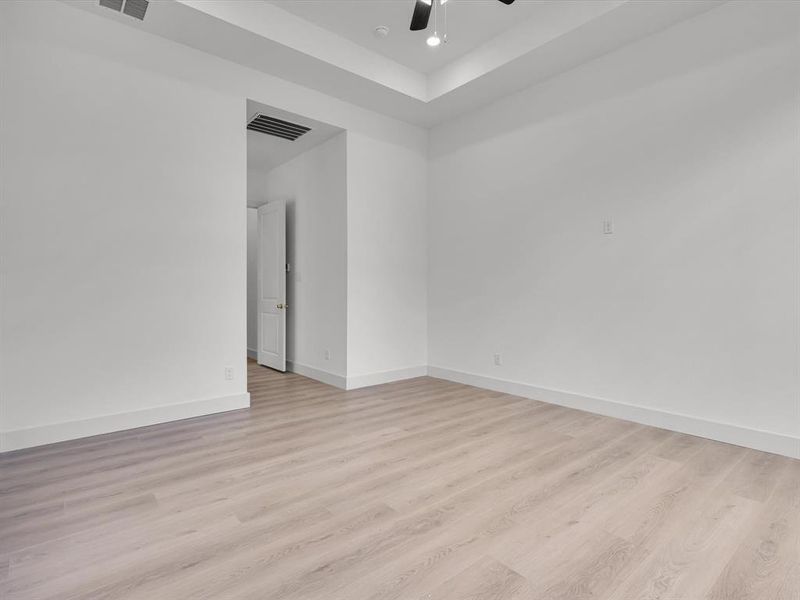 Unfurnished room with light wood finished floors, a raised ceiling, recessed lighting, and ceiling fan Unfurnished room with light wood finished floors, a raised ceiling, recessed lighting, and ceiling fan