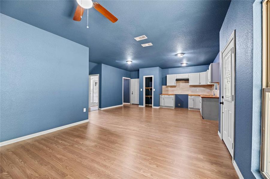 Unfurnished living room featuring light hardwood / wood-style floors and ceiling fan Unfurnished living room featuring light hardwood / wood-style floors and ceiling fan