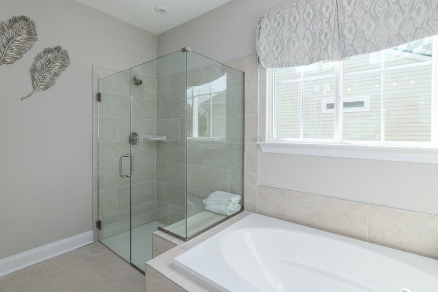 Owner's spa bath with glass shower enclosure