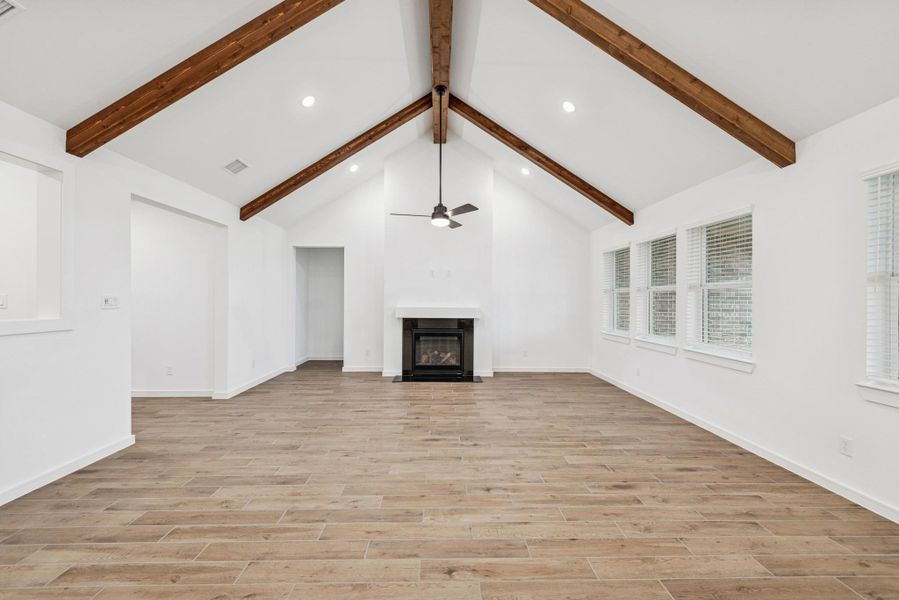 Open dining area and great room with vaulted ceiling and stained beams
