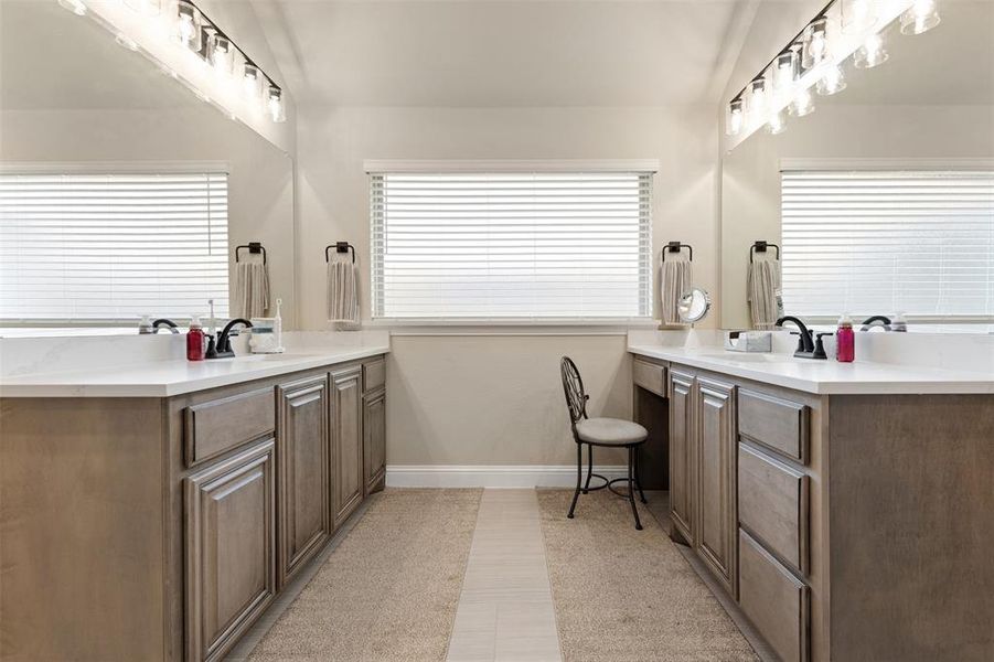 Dual vanities featuring light wood-finish cabinetry and white countertops Dual vanities featuring light wood-finish cabinetry and white countertops