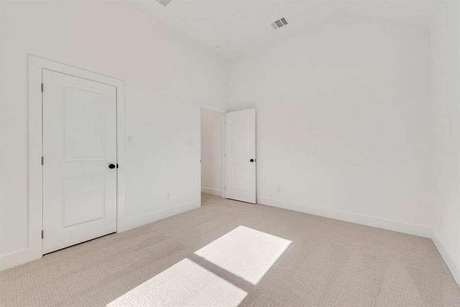 Unfurnished bedroom featuring light carpet and baseboards Unfurnished bedroom featuring light carpet and baseboards