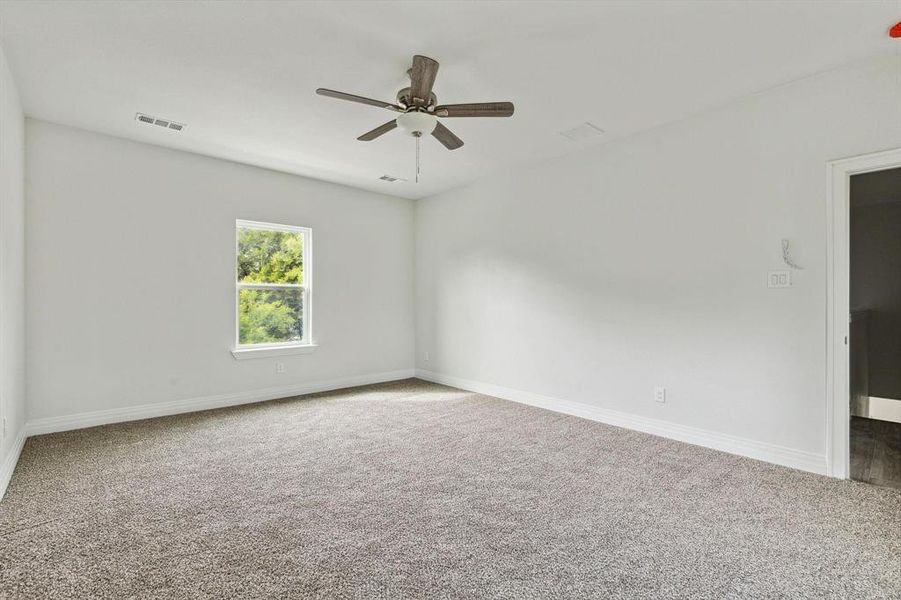 Empty room featuring ceiling fan and carpet