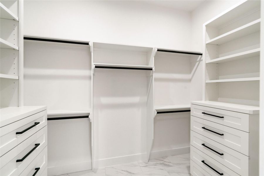 Elegant walk-in closet featuring custom drawers and spacious shelving for ultimate organization.