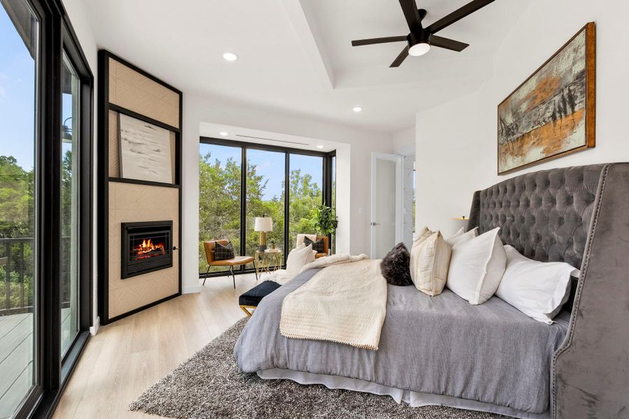 Bedroom featuring light wood-type flooring, access to exterior, recessed lighting, a large fireplace, and ceiling fan
